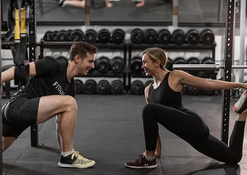 Coach guiding a client through a lunge